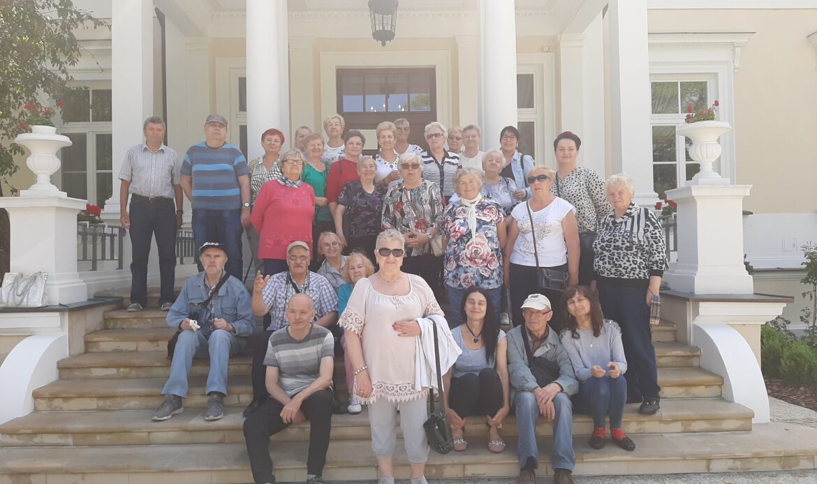 Dorośli pozują do zdjęcia przed Muzeum Rolnictwa w Ciechanowcu