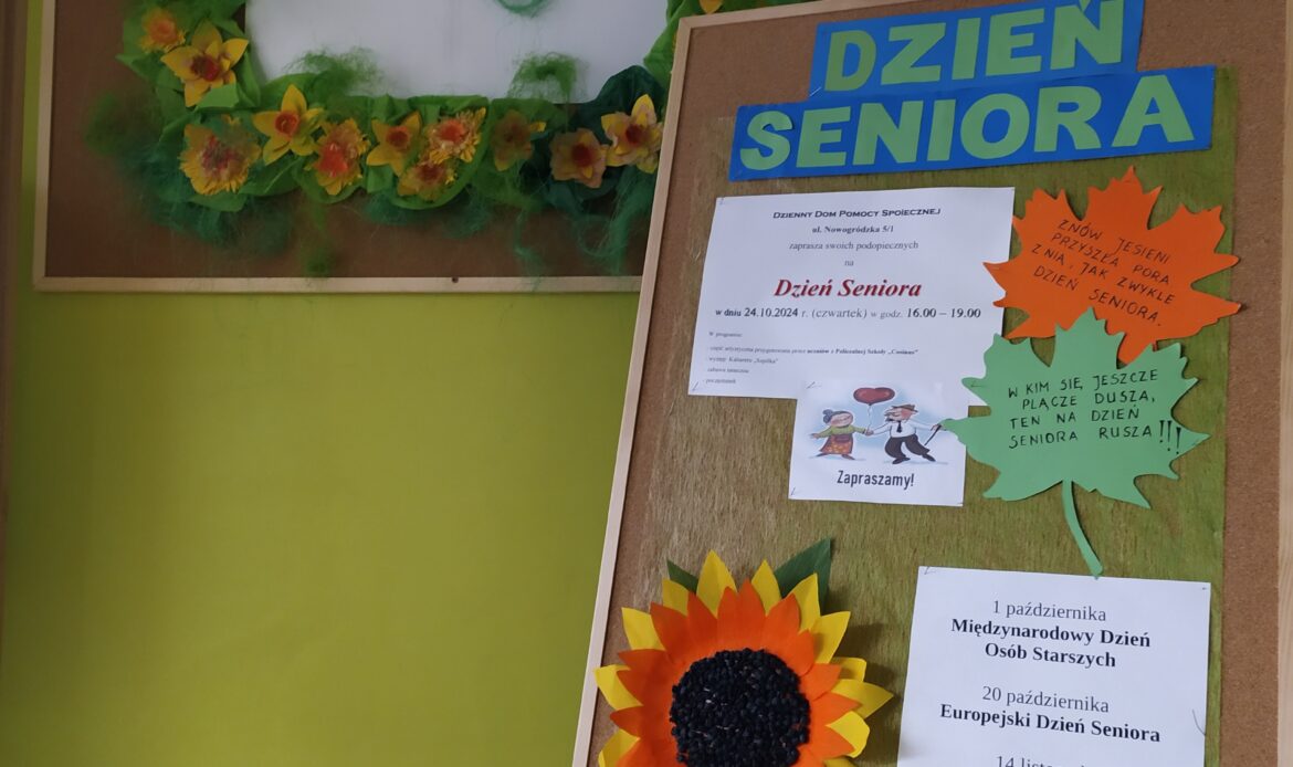 Tablica z kwiatami i sztaluga z informacjami o Dniu Seniora.