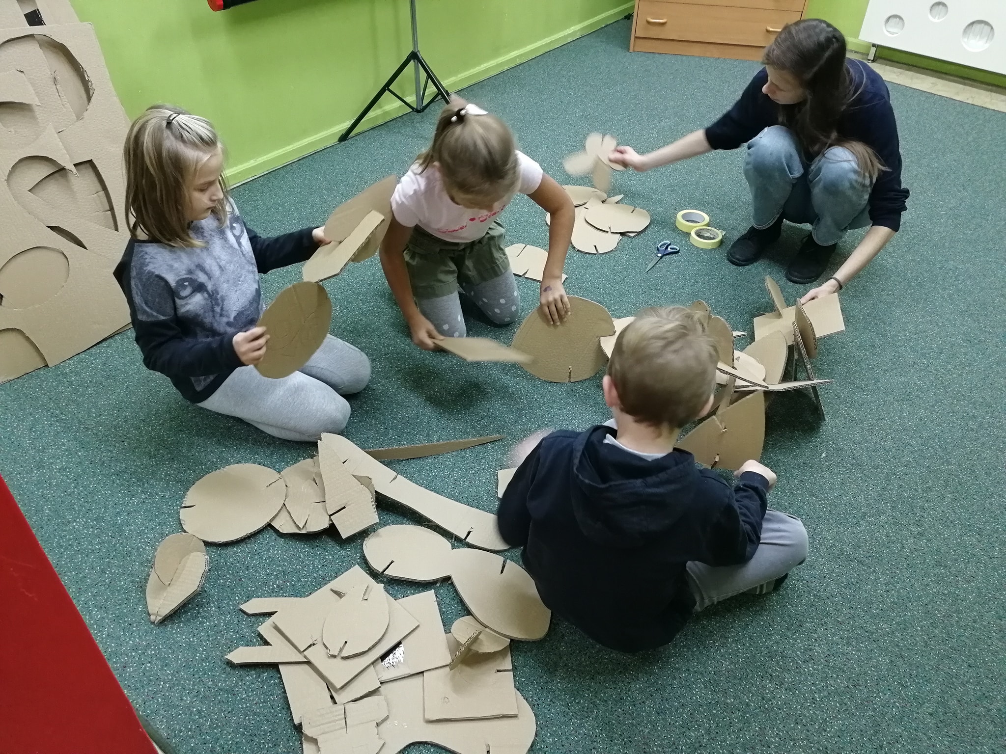 dzieci tworzą pracę plastyczną z kartonów