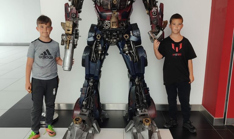 Chłopcy z figurką metalowego robota