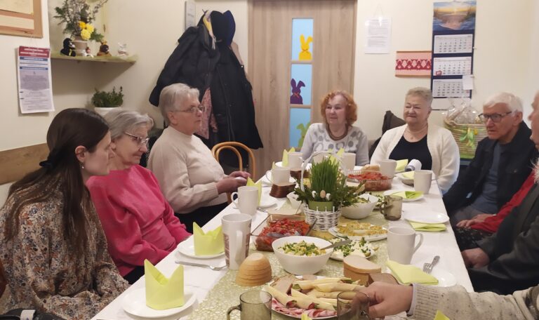 Grupa osób dorosłych i seniorów przy stole.